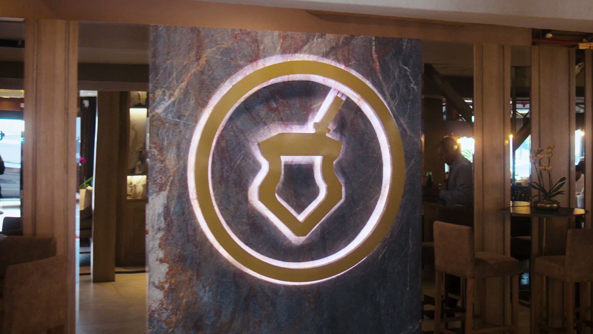 El escudo de O Gaúcho iluminado en el salón de la churrasquería